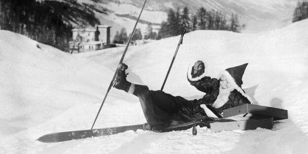 Ein historischen Bild eines Weihnachtsmanns, der auf Skiern gestürzt ist.
