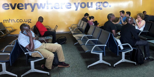 Wartebde Reisende auf dem Flughafen in Entebbe
