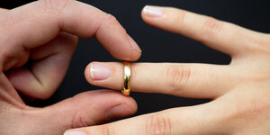 Eine Person steckt einer anderen einen Ehering an den Finger