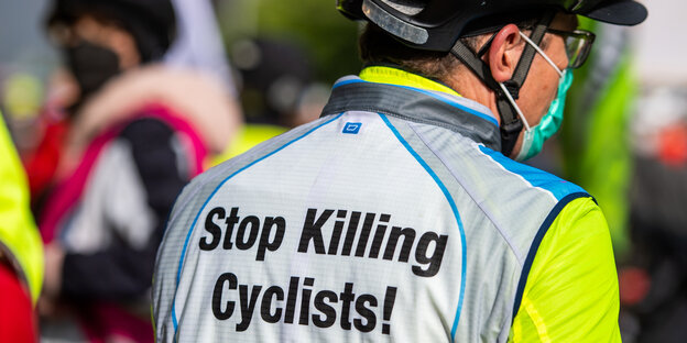 Mann in Radfahrmontur, Schrift auf Rücken "Stop Killing Cyclists"