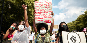Auf einer Black Lives Matter-Demonstration halten Frauen Schilder mit Namen hoch