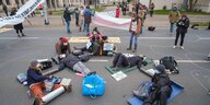 Aktivist*innen von Extinction Rebellion liegen in einem Kreis vor dem Umweltministerium Niedersachsen