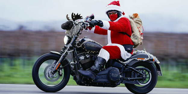 Mann in Nikolauskostüm auf einem Motorrad