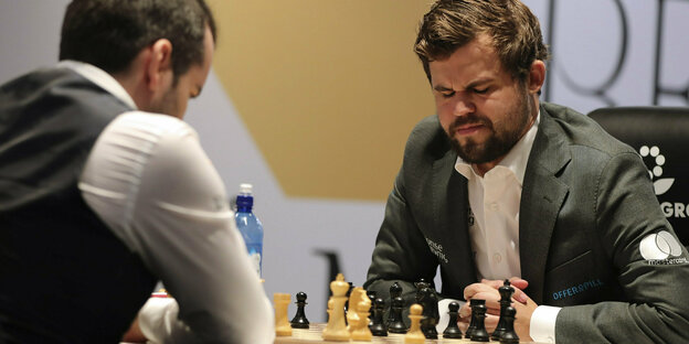 Zwei Schachspieler, Jan Nepomnjaschtschi und Magnus Carlsen, sitzen am Brett.
