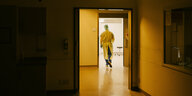 Ein Pfleger in den dunklen Gängen eines Krankenhauses