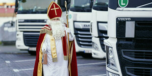 Mann im Nikolauskostüm neben LKW