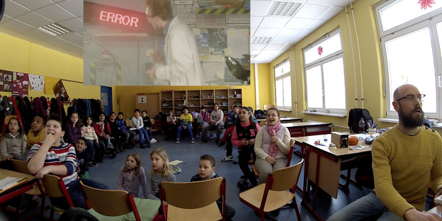 Grundschulkinder in einem Klassenzimmer starren gebannt auf Wand, an die ein Bild gebeamt wird.