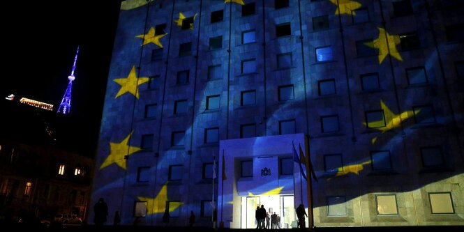 Gelbe Sterne auf einer blauen Flagge, Projektion auf einem Haus