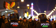 PolizistInnen und Demonstranten mit Deutschlandfahne