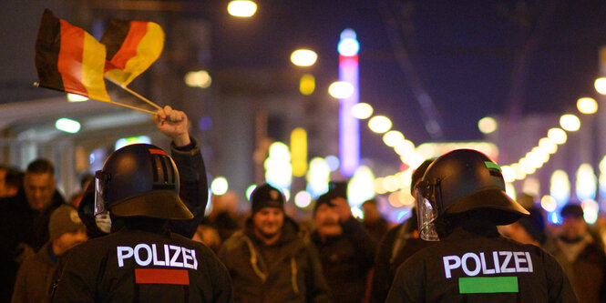 PolizistInnen und Demonstranten mit Deutschlandfahne