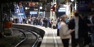 Reisende warten im Hamburger Hauptbahnhof auf einen Zug.