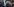 Ein Kind ist als ein Charakter des Videospiels Minecraft an Halloween verkleidet. Es hat eine große, breite Maske auf, die ein verpixeltes Gesicht zeigt. In der Hand hält es ein Schwert aus Pappe. Im Hintergrund sind viele Menschen zu sehen