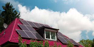 Einfamilienhaus mit Solaranlage auf dem roten Dach