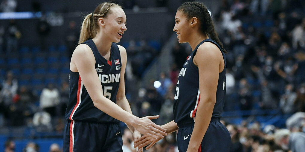 Paige Bueckers und Azzi Fudd geben sich die Hand auf dem Spielfeld