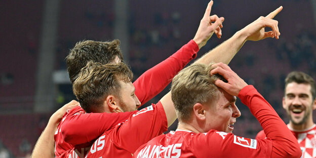 Mit nach oben gestrecktem Zeigefinger bejubeln vier Mainzer Spieler ein Tor