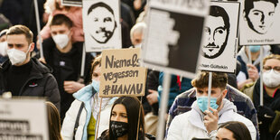 Demonstrierende mit Schildern bei einer Demonstration in Gedenken an den Anschlag von Hanau.