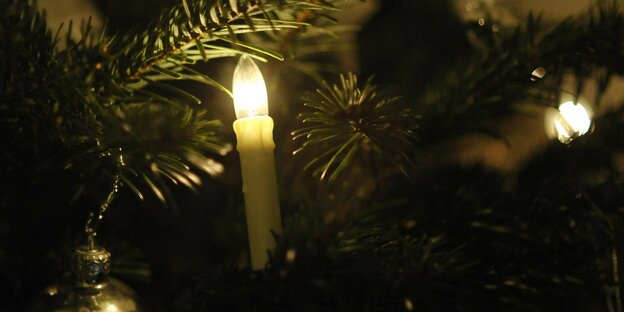 Ein elektrische Kerze an einem Weihnachtsbaum.