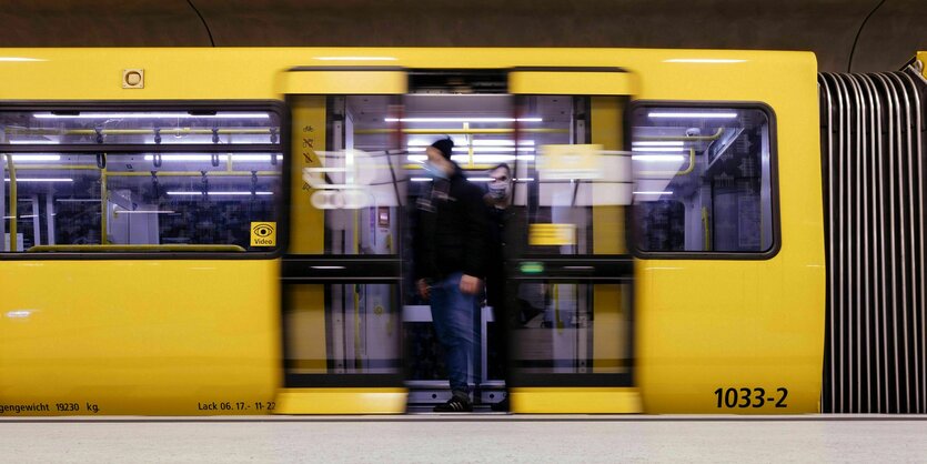 Ein Mann mit Maske steigt aus der U-Bahn