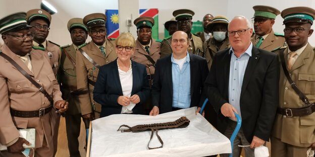 In Uniform gekleidetet Mitglieder der Ovambanderu aus Namibia stehen an einem Tisch im Stadtmuseum Braunschweig