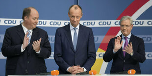 Die CDU-Politiker Helge Braun, Friedrich Merz und Norbert Röttgen stehen an einem Pult