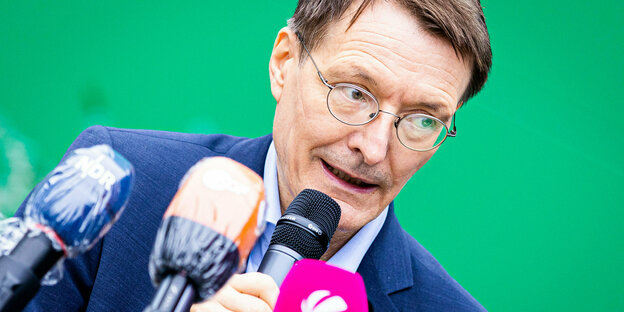 Karl Lauterbach vor grünem Hintergrund Karl Lauterbach vor grünem Hintergrund