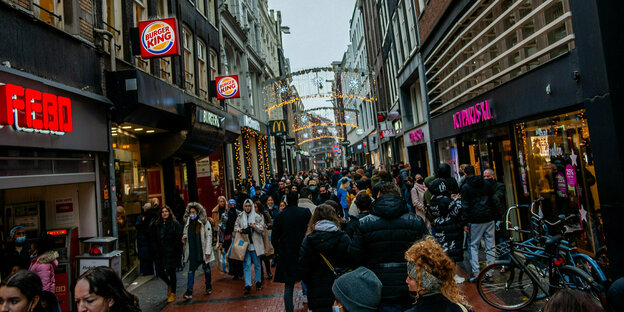 Einkaufsstraße mit Weihnachtsschmuck voller Menschen