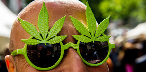 Ein Mann trägt eine Brille in Cannabisblatt-Form