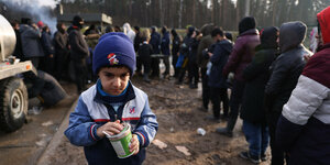 Ein Junge trägt eine Suppendose ineinem Flüchtlingslager.