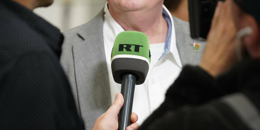 Ein Mikrofon mit der Aufschrift RT in einer Interviewsituation.