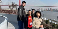 Die rot gekleidete Tennisspielerin Peng Shuai auf einem Aussichtsbalkon in Schanghai in Begleitung von Yao Ming