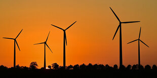 Windräder vor einem Sonnenuntergang.