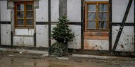 Ein Weihnachtsbaum an einer Mauer eines Fachwerkhaus.