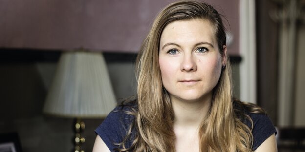 Die Autorin Kirsten Fuchs sitzt in einem Wohnzimmer vor einer Lampe