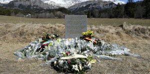 Blumen liegen um den Gedenkstein bei Le Vernet in den französischen Alpen.