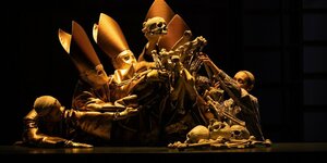 Totenköpfe mit goldenen Bischofsmützen bilden eine gestaffelte Skulptur