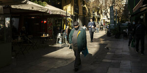 Ein Mann trägt eine Schutzmaske und geht in der Nähe des Omonia-Platzes in Athen spazieren