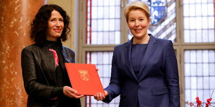 Bettina Jarasch überreicht Franziska Giffeyeine Urkunde