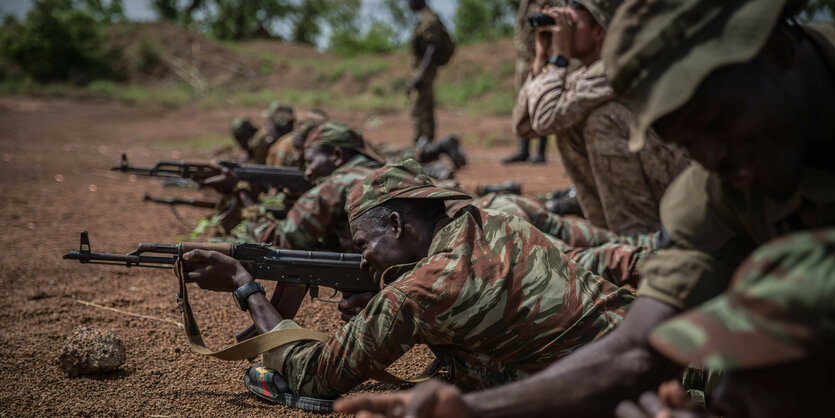 Soldaten liegen auf dem Boden und zielen mit Waffen