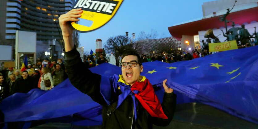 eine riesige EU-Flagge und ein Banner mit der Aufschrift "Alle für Gerechtigkeit"