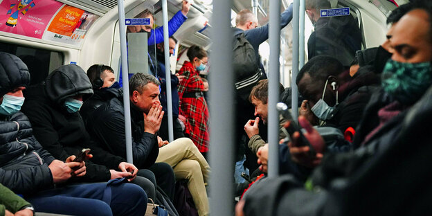 Viele Menschen sitzen sehr eng in einer Ubahn