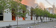 Ein Gebäude mit zerschlagenen Fenstern brennt