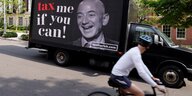 Auf der Ladefläche eines Lastwagens steht ein Plakat mit dem Kopf von Amazon-Gründer Jezz Bezos und der Aufschrift "Tax me if you can!"
