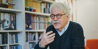 Politiker und Gewerkschafter Hans-Peter de Lorent sitzt in seinem Arbeitszimmer vor einer Bücherwand