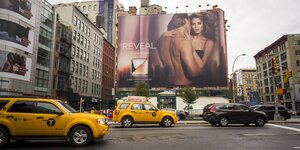 Straßenszene au New York mit großer Parfumplakatwerbung mit nackten Models