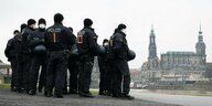 Polizisten stehen am Ufer der Elbe in Dresden vor der Kulisse der Altstadt