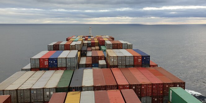 Der Blick von der Brücke über ein langes Containerschiff