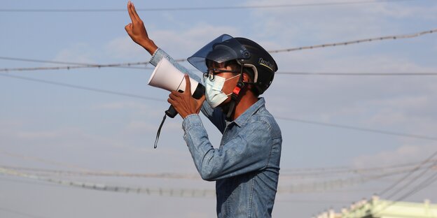 Ein Demonstrant in Mandalay zeigt den Drei-Finger-Gruß i