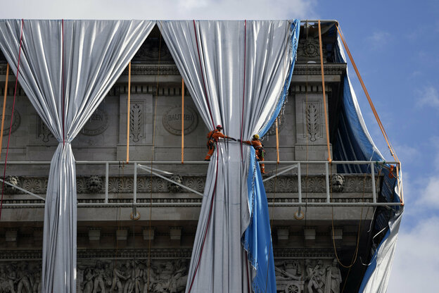 Zwei Installateure montieren Christos Vorhänge auf dem Triumphbogen
