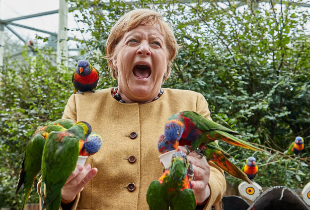Angela Merkel mit Papagaeien lacht