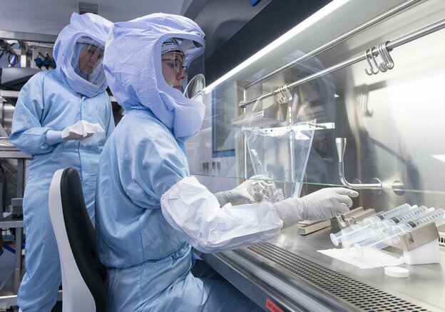zwei Frauen mit Mit Ganzkörper-Schutzanzügen in einem Labor
